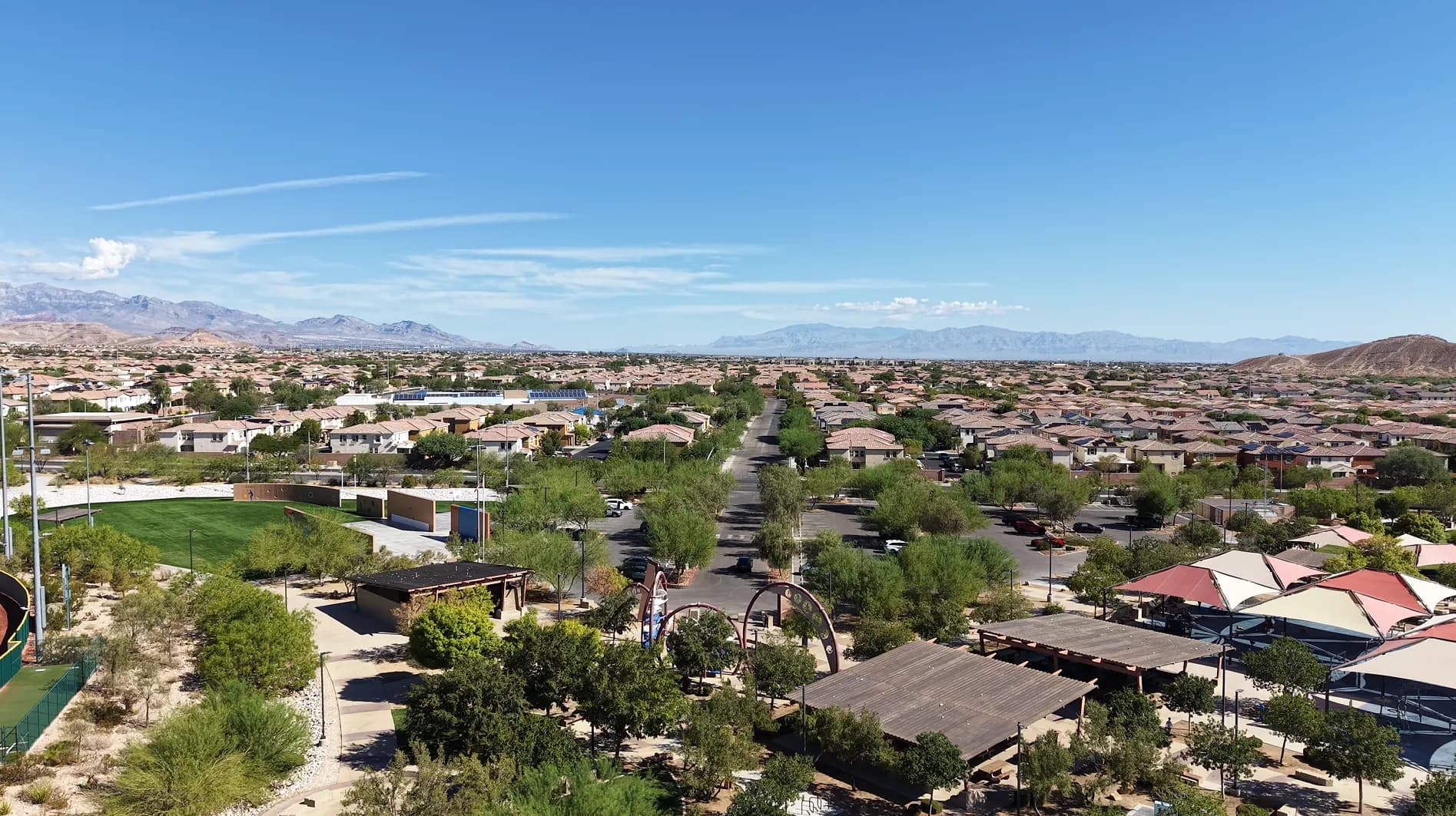 Aerial drone view of a park in Mountain's Edge, a master-planned Southwest Las Vegas community, with the valley and mountains beyond.