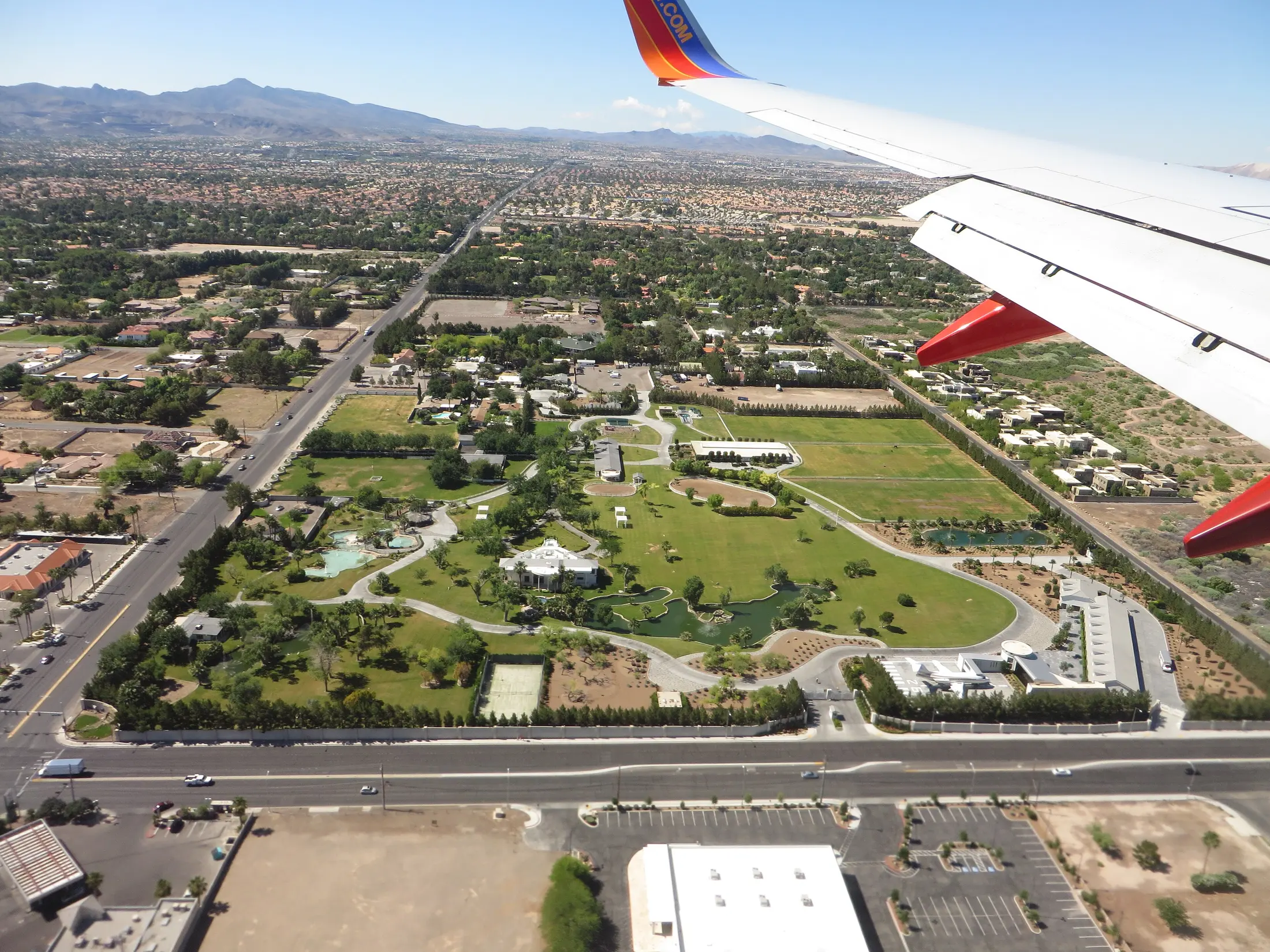 Aerial view from a departing airplane of Wayne Newton's Casa de Shenandoah estate, showing the mansion, ponds, and grounds surrounded by the Las Vegas Valley, May 2015